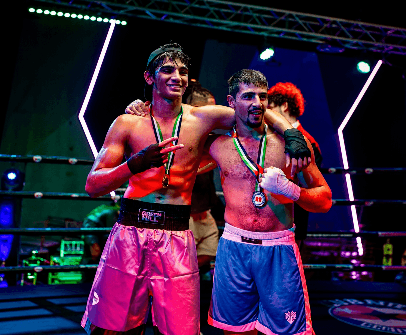 Two fighters celebrating with medals and the UAE flag